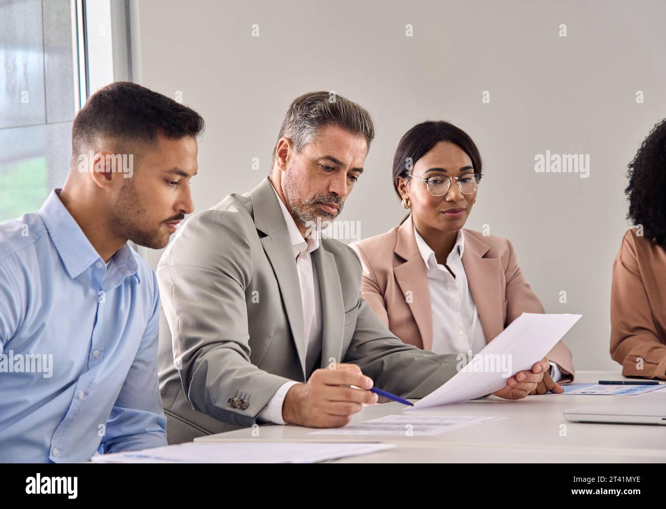 Homme d'affaires sérieux vérifiant le document lors d'une réunion avec des experts en droit financier. Banque D'Images