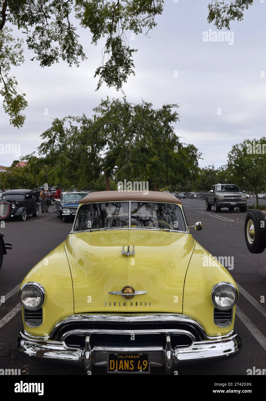 Voiture classique jaune vintage garée dans une rangée de voitures similaires dans un parking Banque D'Images