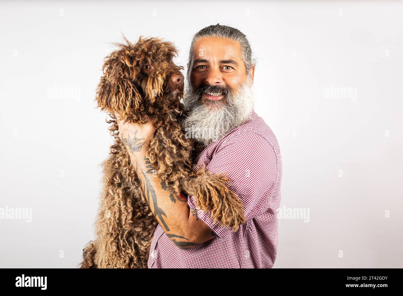 Heureux homme européen tenant chien d'eau mignon, souriant à la caméra, posant avec animal de compagnie Banque D'Images