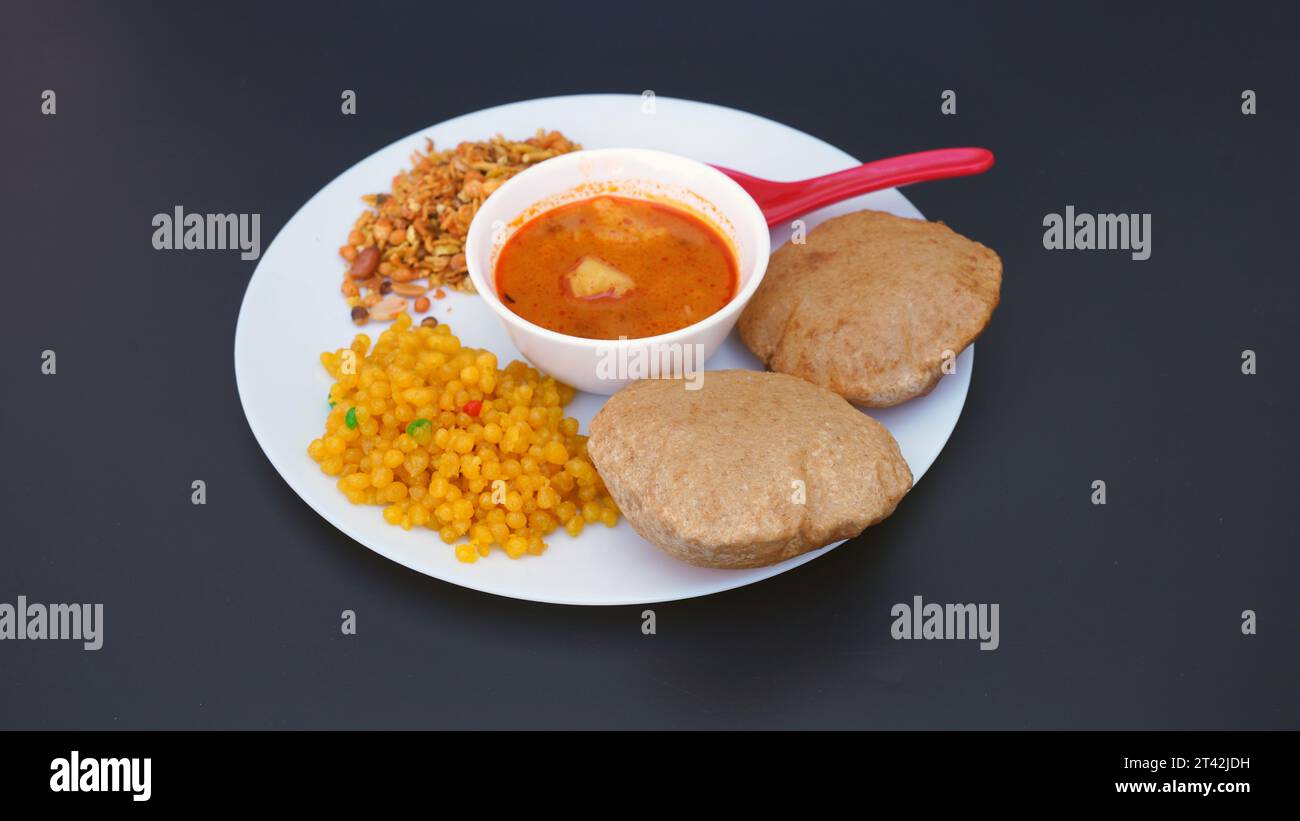 Cuisine indienne - Puri Bhaji et kheer. Recette épicée semi-sèche de pommes de terre du nord de l'Inde également connue sous le nom de Batata ou Aloo ki Sabji, curry de pommes de terre ou curry dum alu Banque D'Images