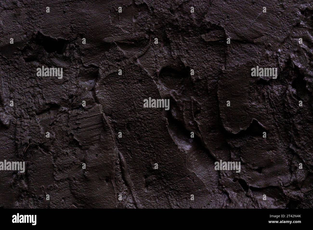 Texture de coups de béton frais sur un mur sur un chantier de construction. Arrière-plan sombre. Banque D'Images