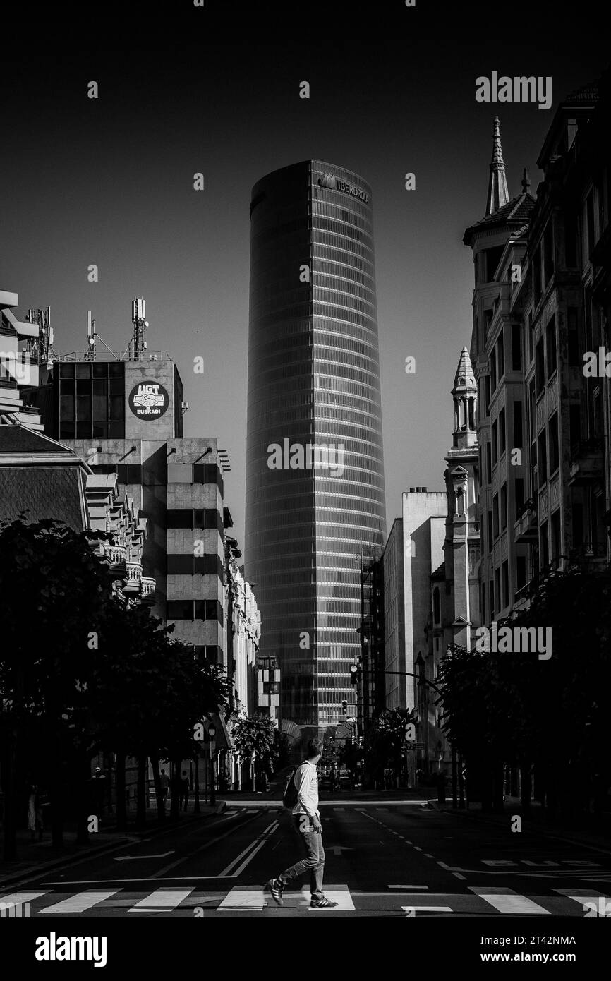 Une voiture vintage de style rétro roule sous la pluie dans une rue de la ville, avec des bâtiments, des lampadaires, et un trottoir humide visibles en arrière-plan Banque D'Images