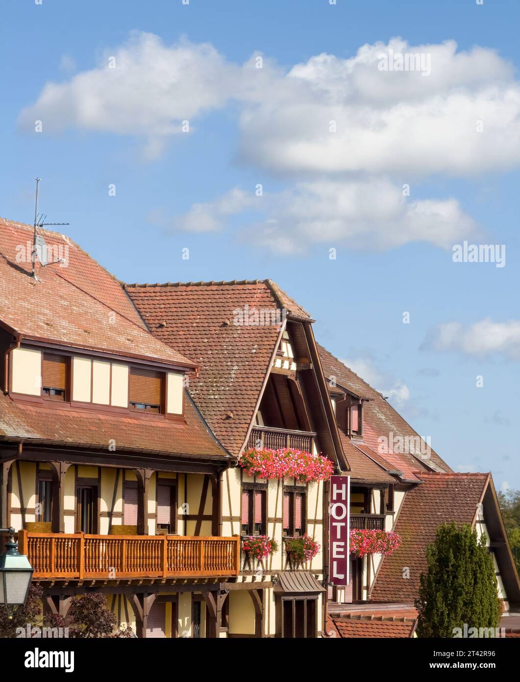 Une élégante vue verticale d'une maison traditionnelle alsacienne à colombages, présentant son architecture distinctive, complétée par de larges balcons spacieux et une grande inscription DE L'HÔTEL Banque D'Images