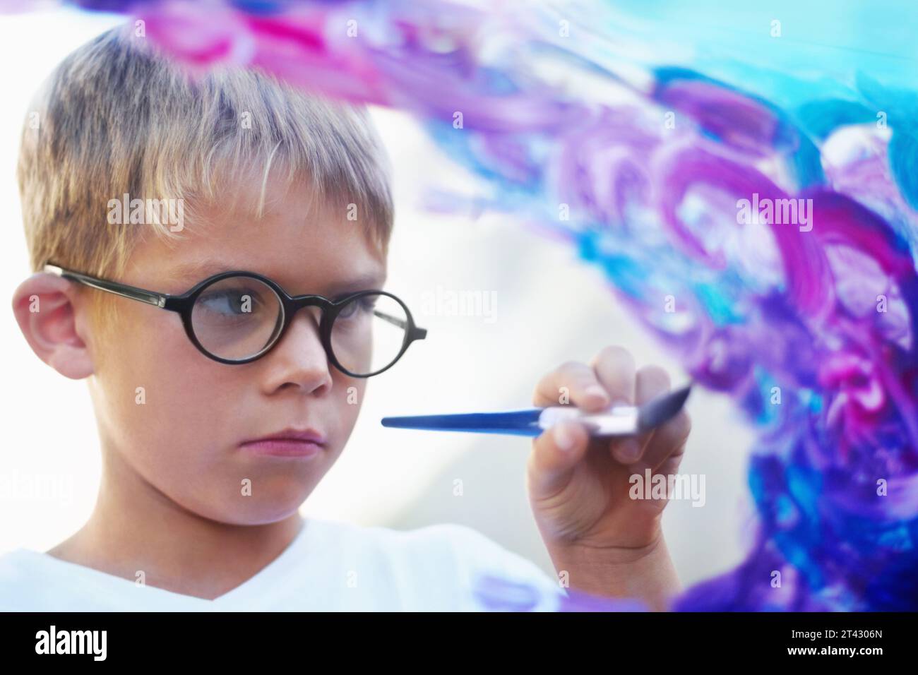 Garçon peignant sur verre, pinceau et créant des œuvres d'art avec des lunettes, l'éducation et l'apprentissage. Personne, enfant et enfant avec art, étudiant et enseignant avec Banque D'Images