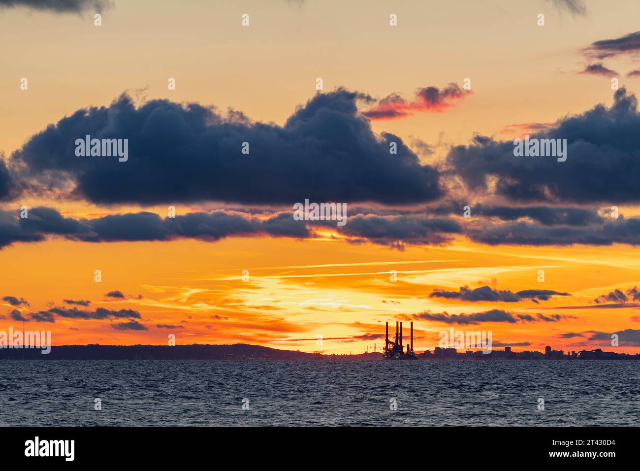 Le soleil couchant illuminant l'horizon avec Sea Challenger détouffé le ciel coloré Banque D'Images