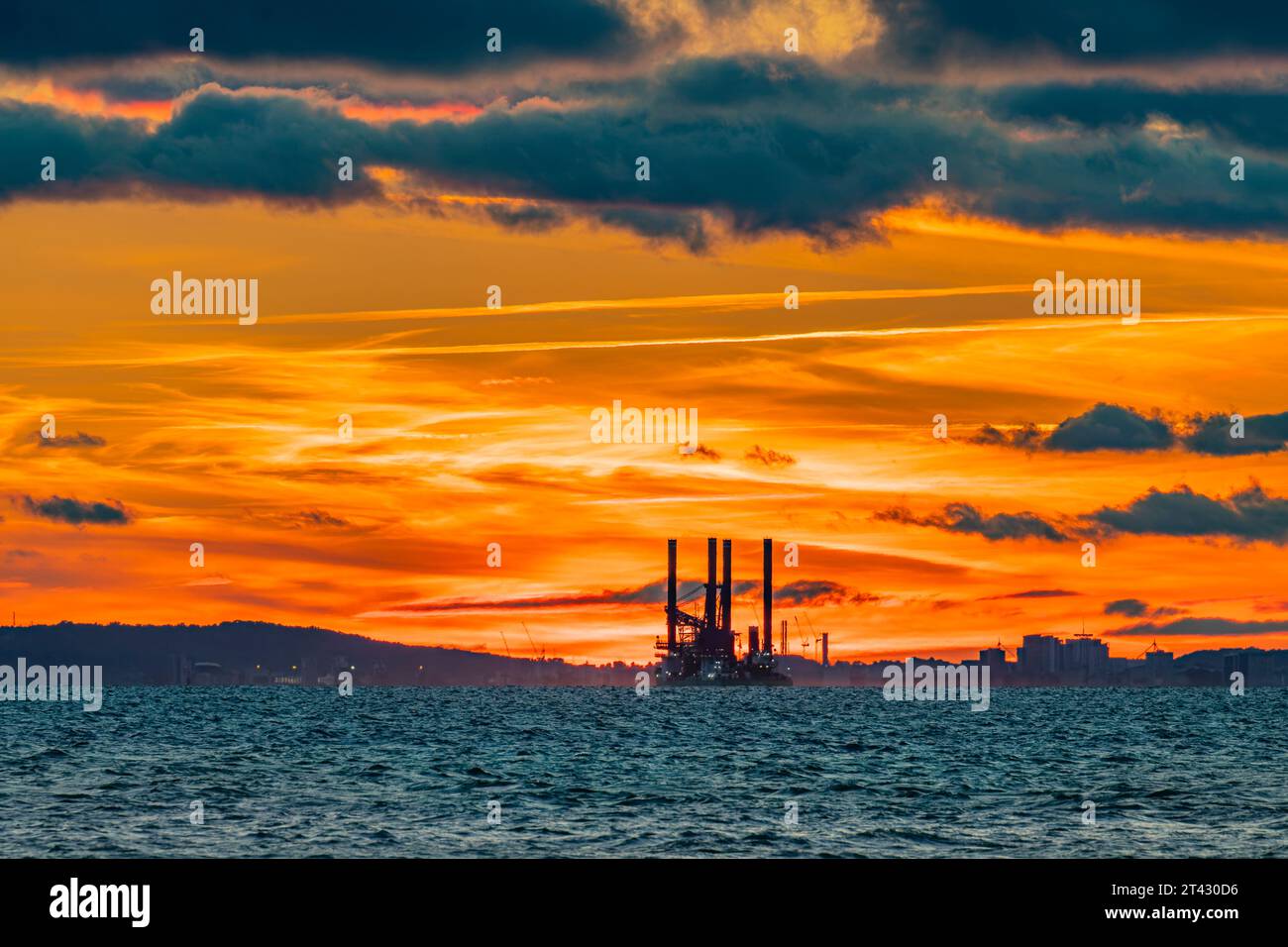 Le soleil couchant illuminant l'horizon avec Sea Challenger détouffé le ciel coloré Banque D'Images