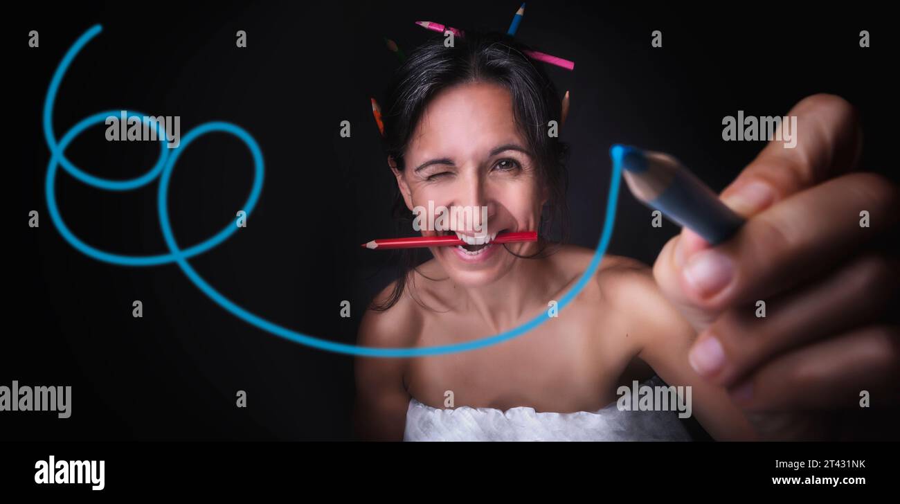 Portrait d'une femme souriante peignant sur un objectif d'appareil photo Banque D'Images