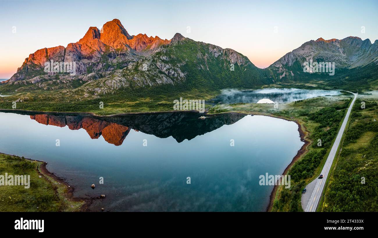 Vue aérienne d'une route et reflets de montagne dans un lac, Svolvaer, Austvagoya, Lofoten, Nordland, Norvège Banque D'Images