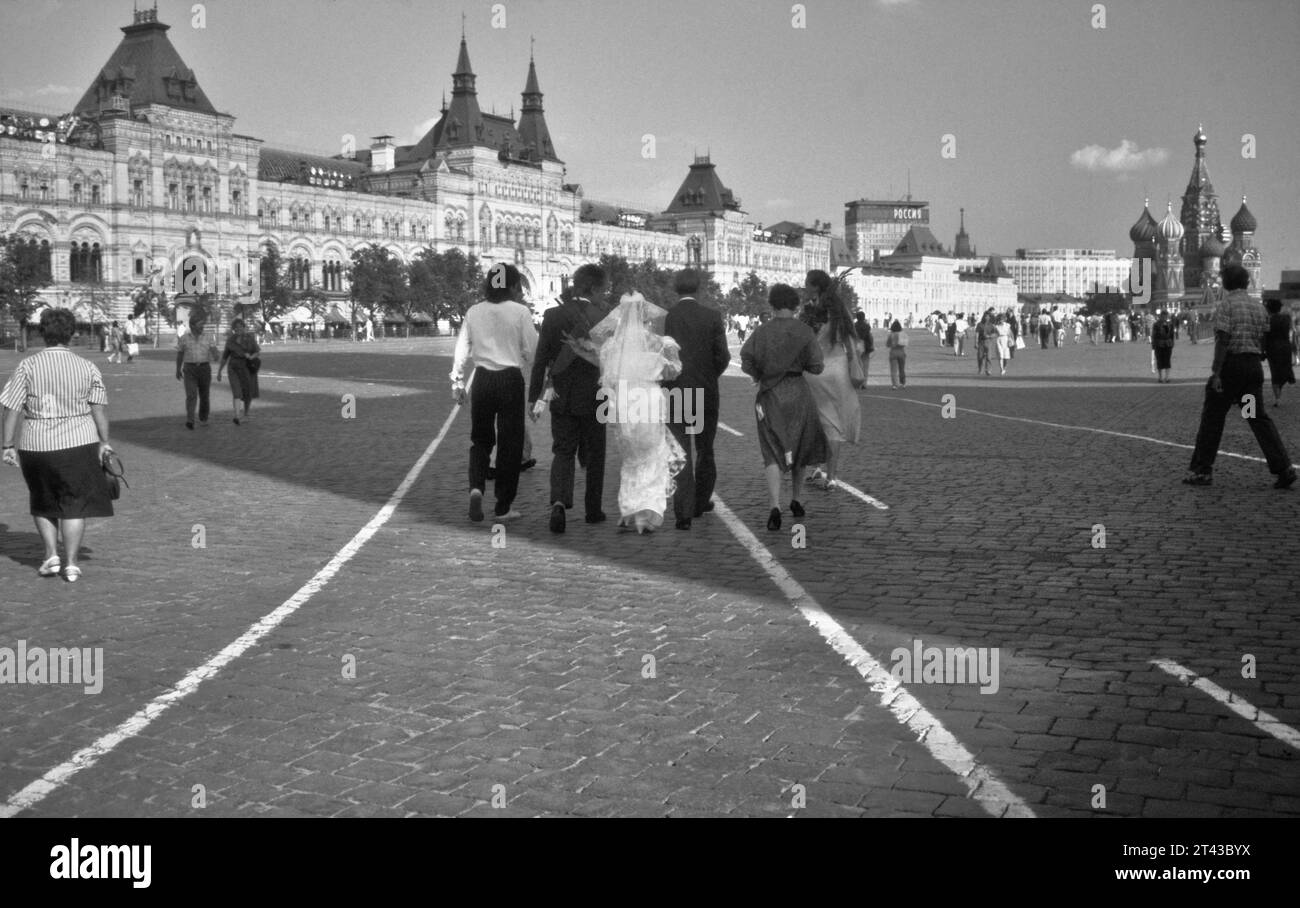 Archive image historique d'Une fête nuptiale russe marchant à travers la place Rouge vers le Kremlin et la cathédrale Saint-Basile, Moscou 1990 Banque D'Images