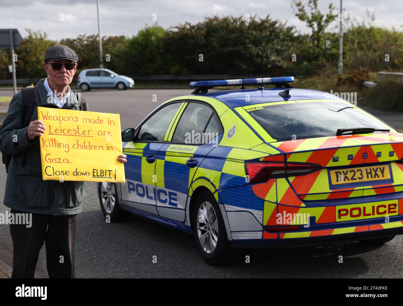 Leicester, Leicestershire, Royaume-Uni. 28 octobre 2023. Un manifestant porte une banderole appelant à la fermeture d'Elbit lors d'une manifestation pro-palestinienne et dépose une banderole près de la base de UAV Tactical Systems. ElbitÕs UAV Tactical Systems est une société franco-israélienne fabriquant des drones vendus à l’armée britannique, à Israël et aux marchés internationaux de l’armement. Crédit Darren Staples/Alamy Live News. Banque D'Images