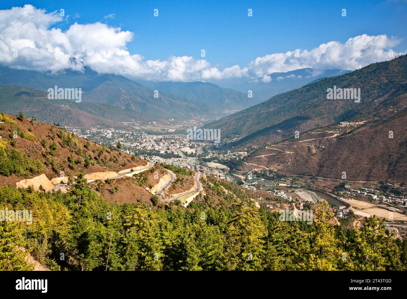 Une route serpente dans la vallée où la plus grande ville du Bhoutan, Thimphu, s'étend à la base des contreforts de l'Himalaya. Banque D'Images