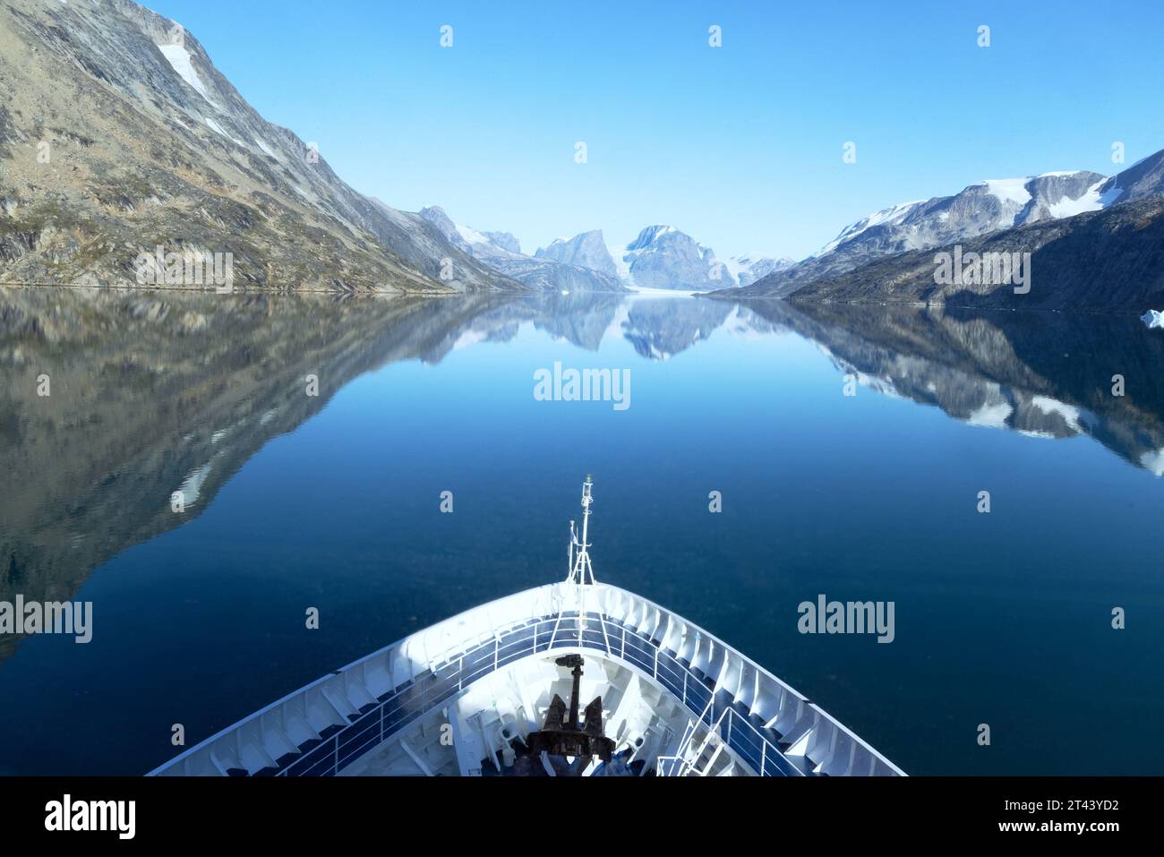 Arctic Cruise ; Un bateau naviguant dans le fjord de Skjoldungen, dans l'est du Groenland en été ; montagnes, glace, glaciers, paysage et ciel bleu. Arctic Travel. Banque D'Images