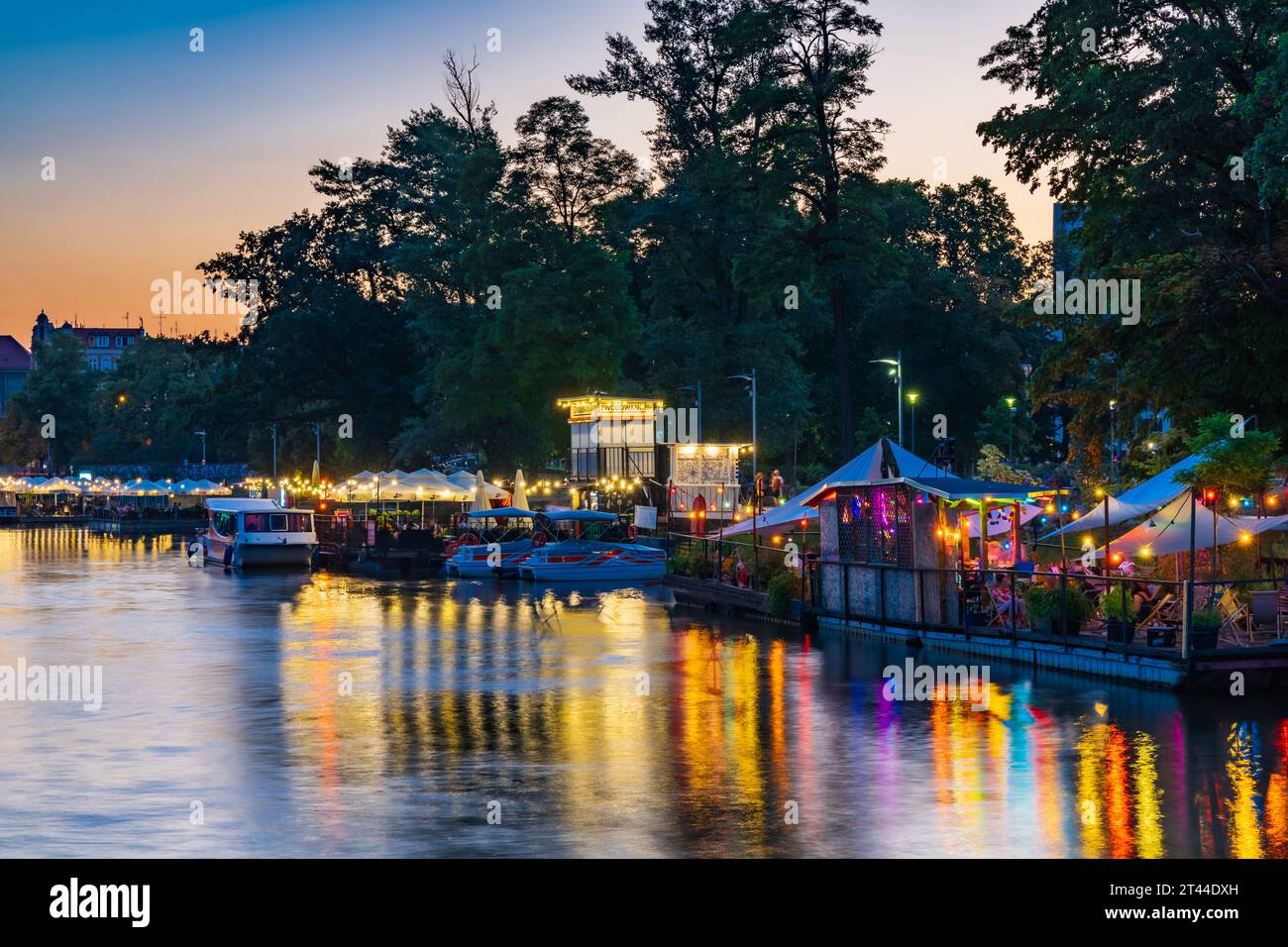 Wroclaw, Pologne - juin 25 2023 : façades de bars et restaurants modernes sur l'eau près de l'île et plein de petites lumières incandescentes autour Banque D'Images
