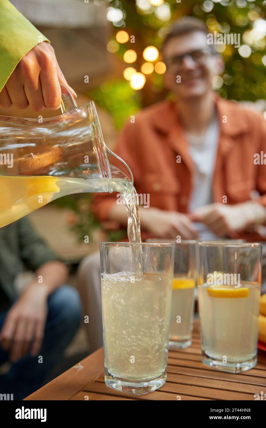 Amis à table avec de la limonade fraîche s'amusant au pique-nique en plein air Banque D'Images