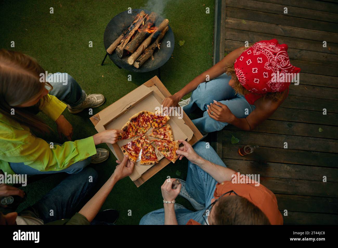 Vue aérienne sur un groupe d'amis mangeant une pizza à proximité brûlant un feu de camp Banque D'Images