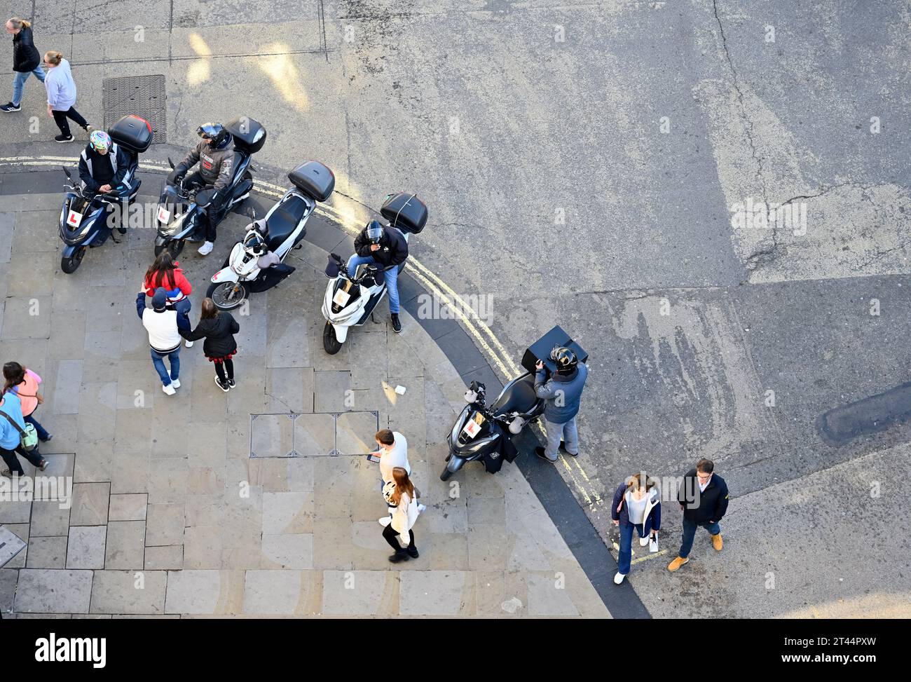 Vue du dessus, les motos de scooter de livraison de rangée garées sur le trottoir et les piétons passant, Oxford Banque D'Images