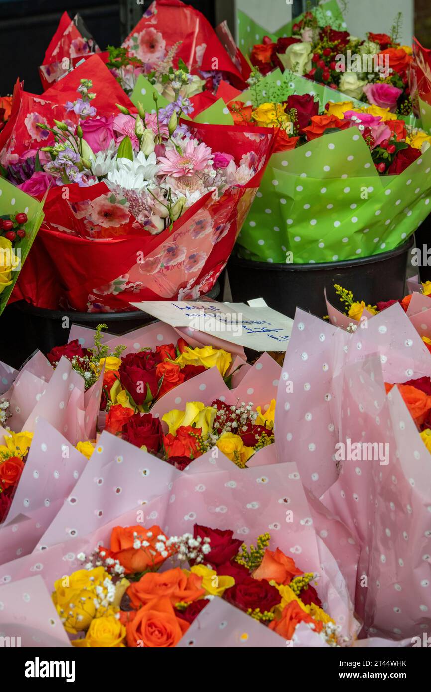 bouquêtes de fleurs fraîchement coupées sur un étal de fleuristes enveloppé dans plastc cellophane .floral affichages et bouquets sur une place du marché. Banque D'Images