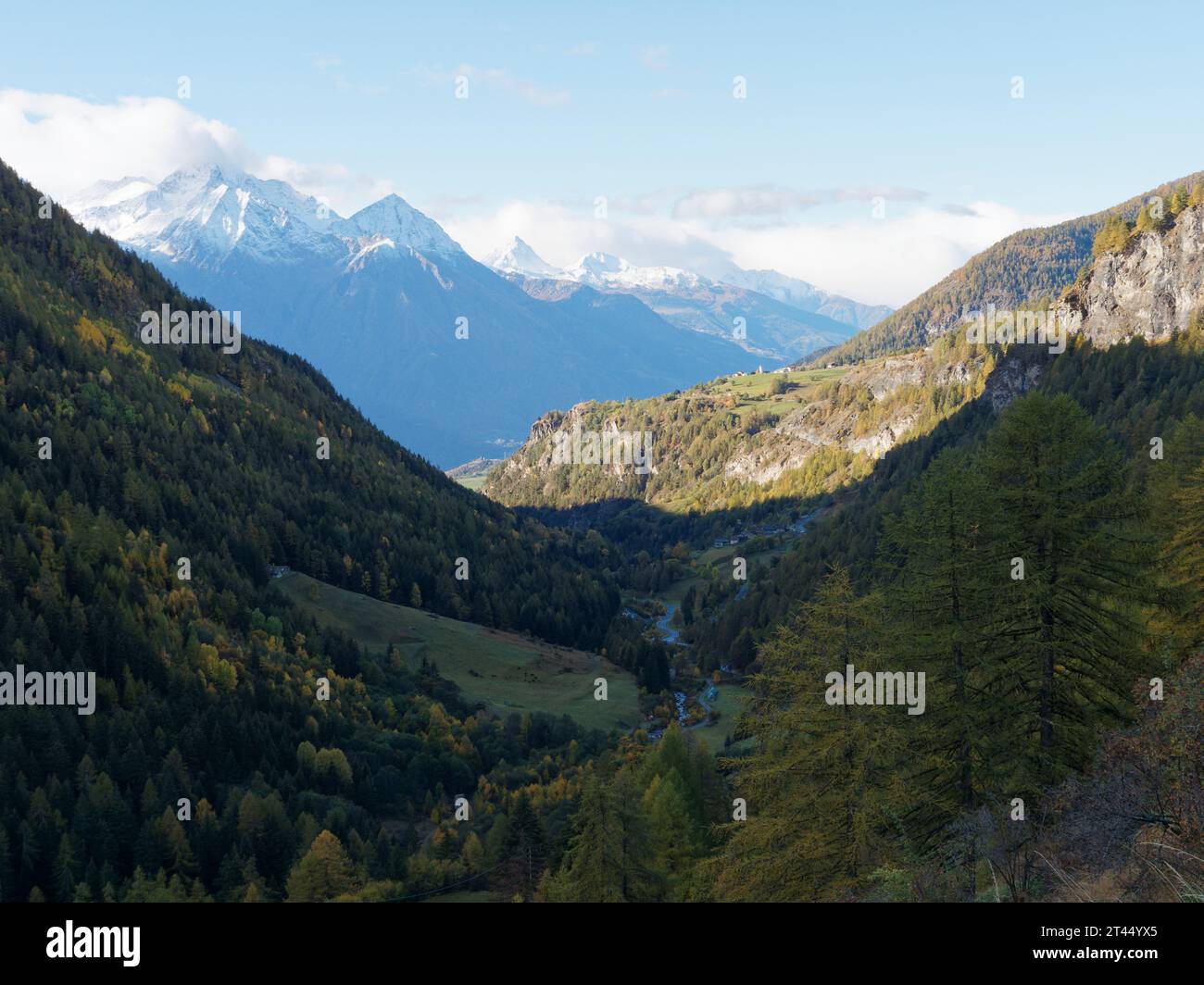 Vallée escarpée avec des forêts à feuilles persistantes et des sommets alpins enneigés un jour d'automne dans la vallée d'Aoste NW Italie. 27 octobre 2023 Banque D'Images