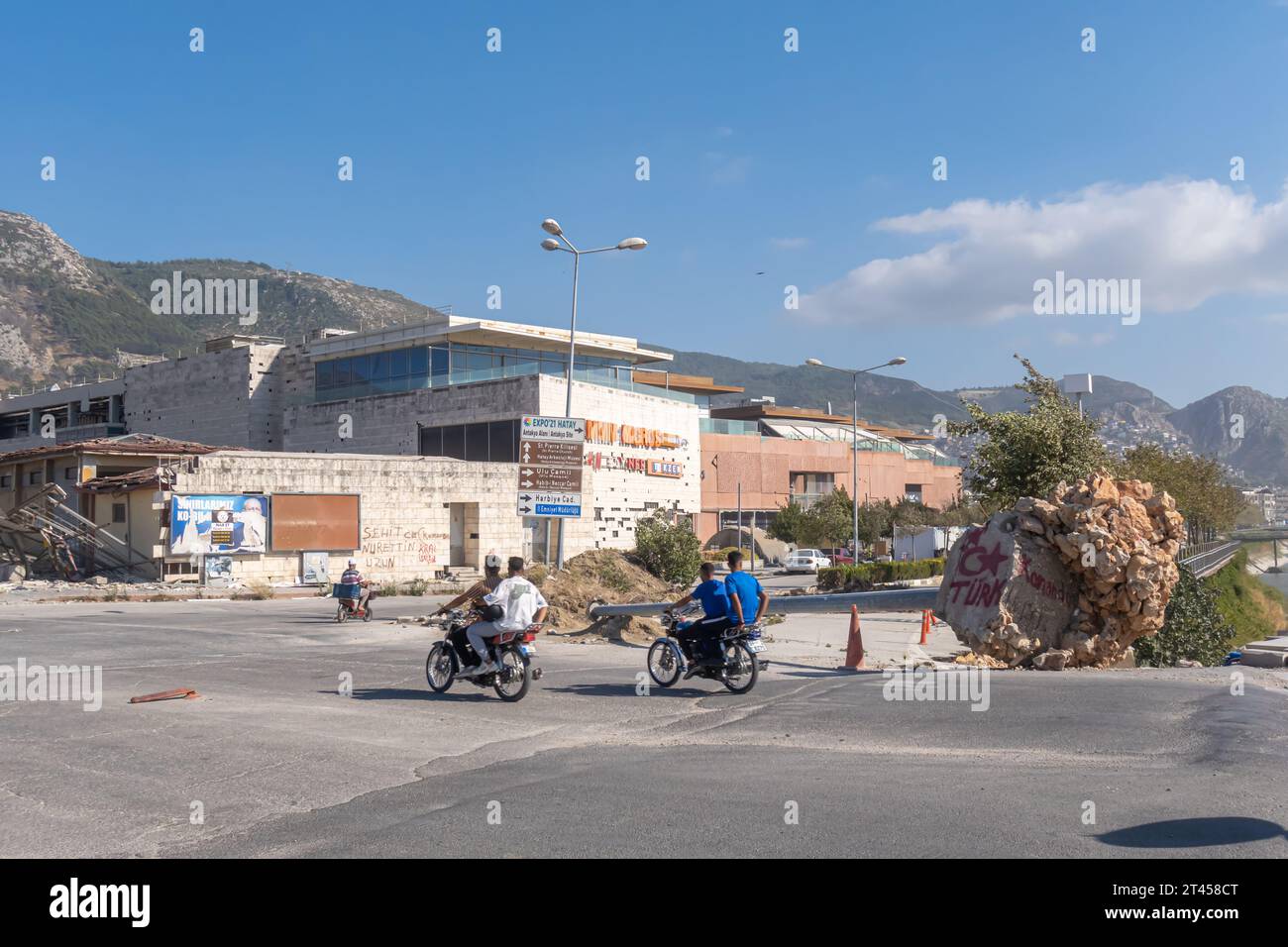 Les motards passent à travers le pont, Love Turkey peint sur la palle tombée dans le centre d'Antakya Turquie, après le tremblement de terre 2023 Banque D'Images