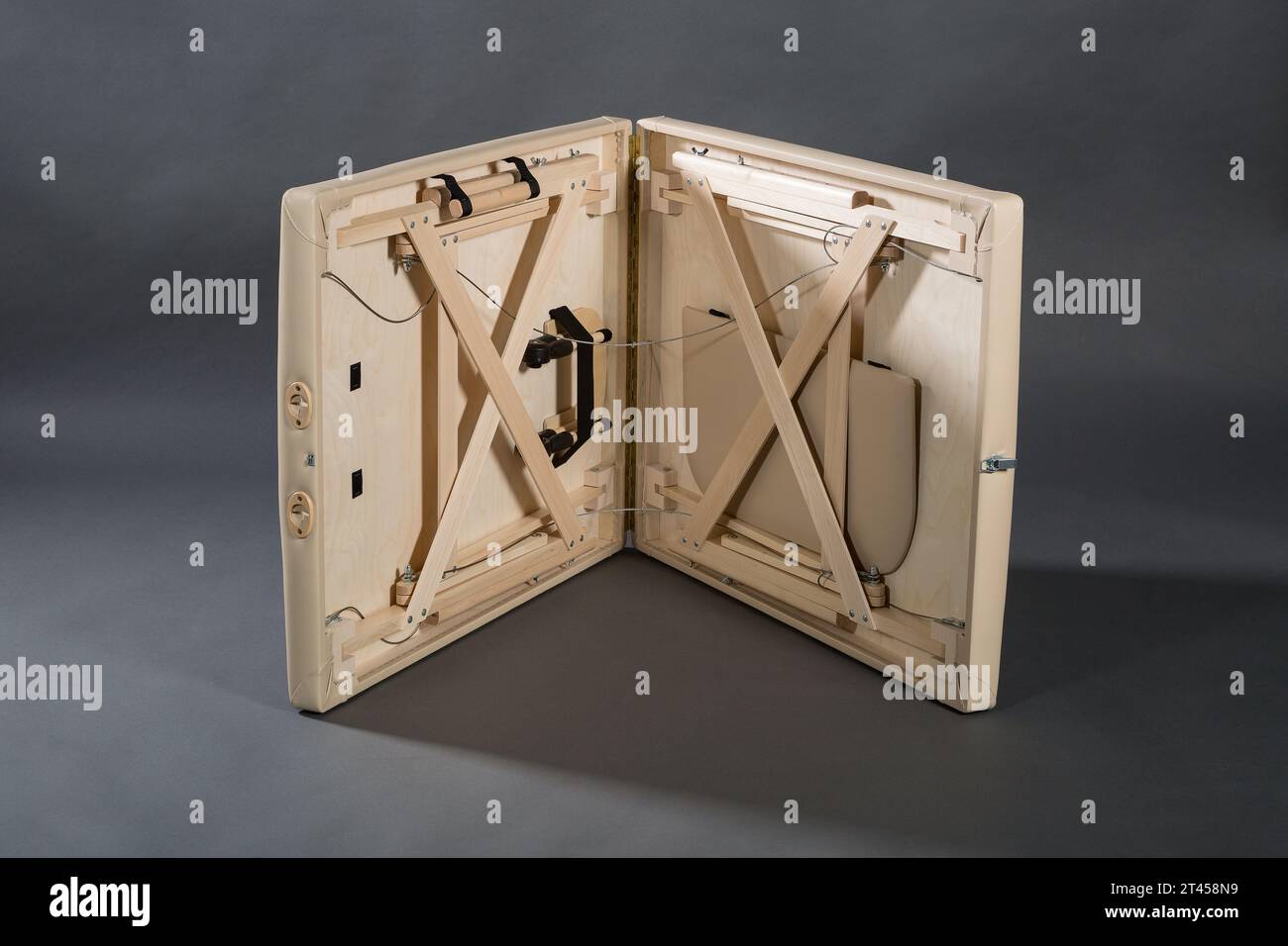 Table de massage pliante portable pour salle de traitement de physiothérapie sur le fond sombre. Banque D'Images