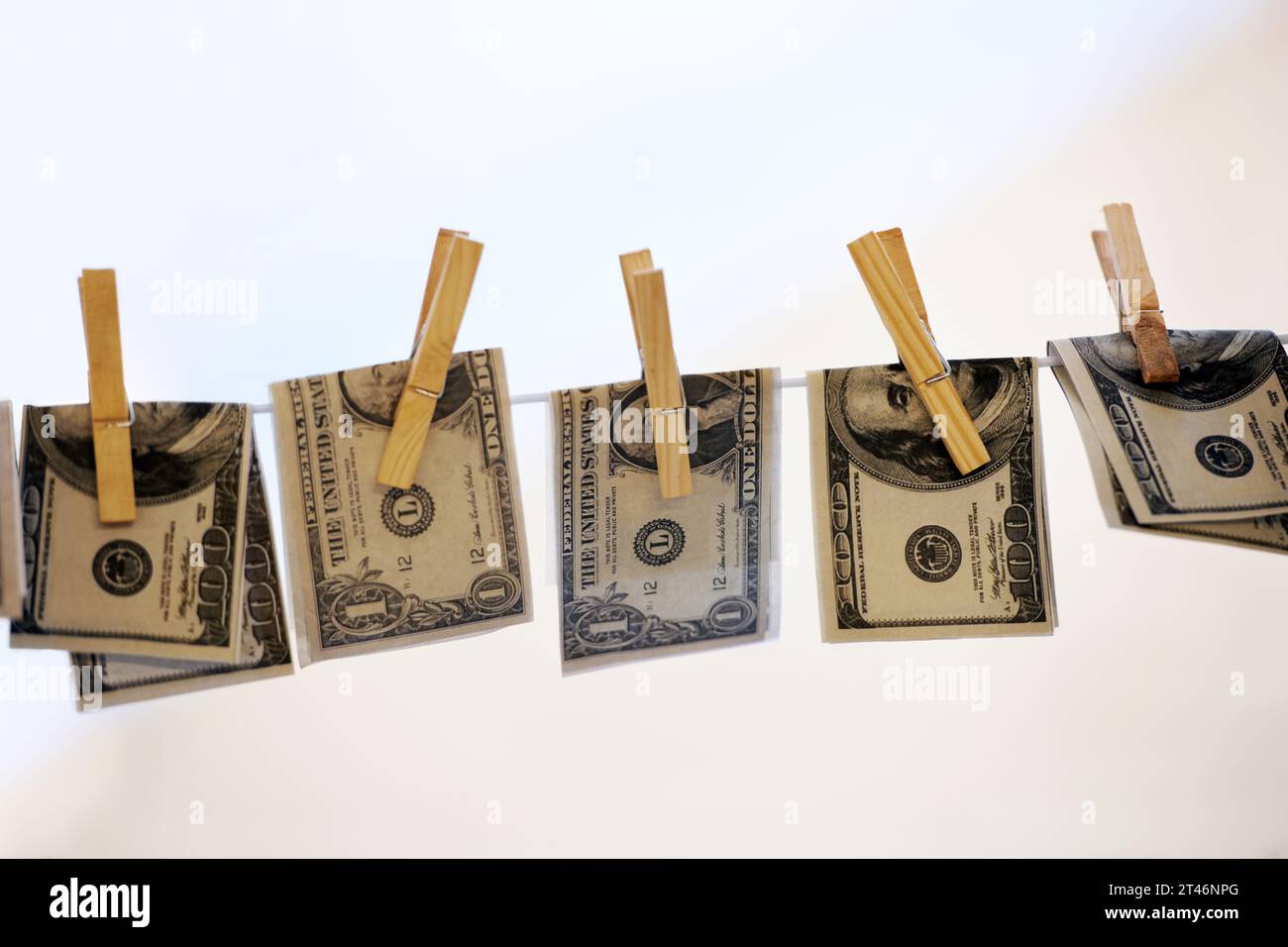 Finance, pegs et blanchiment d'argent avec des billets de banque sur une ligne de lavage pour crime en col blanc ou fraude. Financier, cash et nettoyage avec dollar américain Banque D'Images