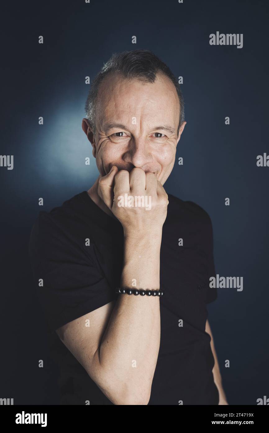 Photographie de t-shirt modèle homme acteur en studio posant avec un éclairage créatif. Banque D'Images