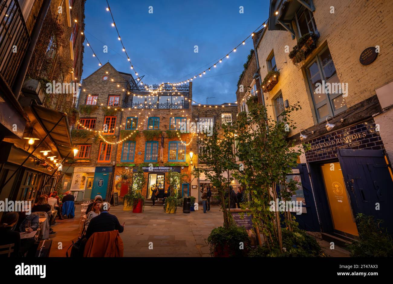 Londres, Royaume-Uni : Neal's Yard dans le quartier de Covent Garden au centre de Londres. Les gens assis à l'extérieur d'un restaurant le soir. Banque D'Images