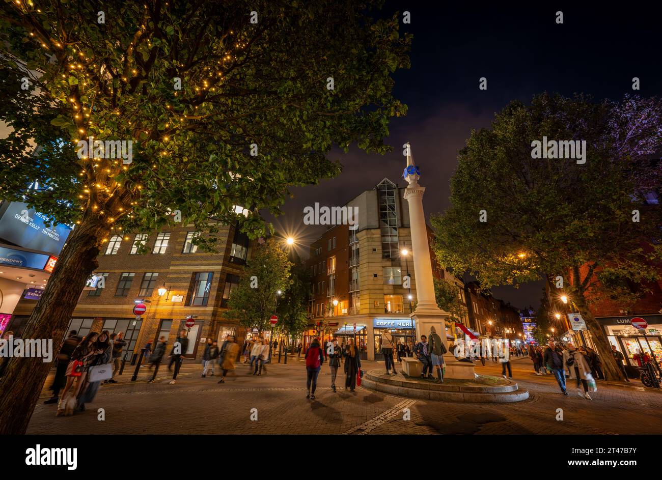 Londres, Royaume-Uni : rond-point Seven Dials dans le quartier de Covent Garden au centre de Londres. Les gens marchent dans la rue la nuit. Banque D'Images