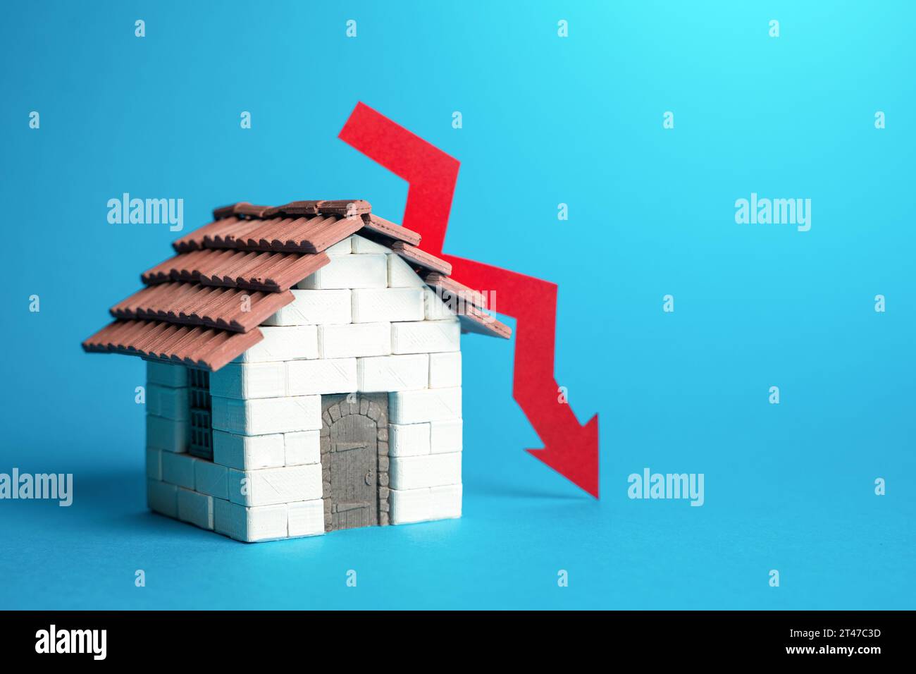 Maison et flèche rouge vers le bas. Baisse des prix du logement. Non-rentabilité des investissements, chute des prix sur le marché immobilier. Baisse de la demande, construction Banque D'Images