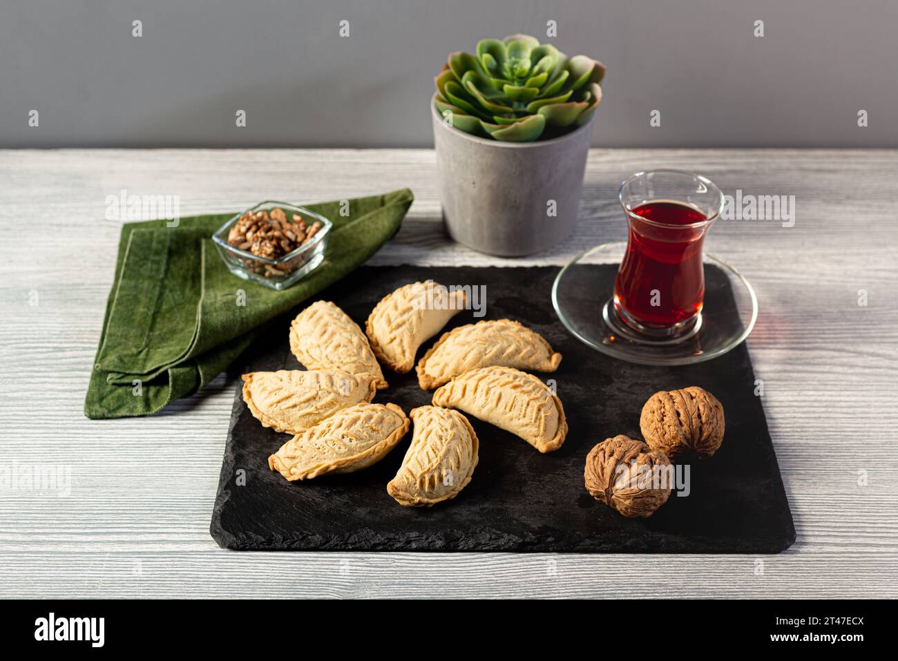 Biscuits classiques de Shekerbura azerbaïdjanais, remplis de noix, accompagnés de thé rouge dans un verre armudu. Banque D'Images