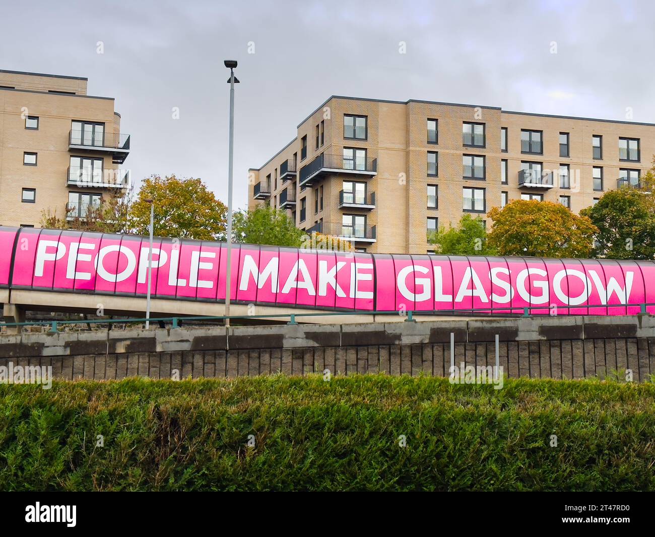 Les gens font le signe de bannière de slogan Glasgow sur la passerelle du tunnel de la ville Banque D'Images