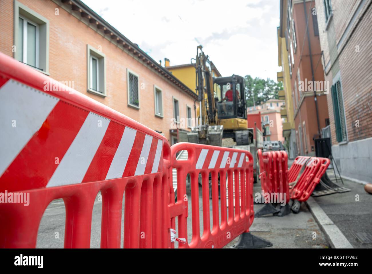Barrières rouges marquées comme sécurité dans les travaux de construction avec pelle en arrière-plan Banque D'Images