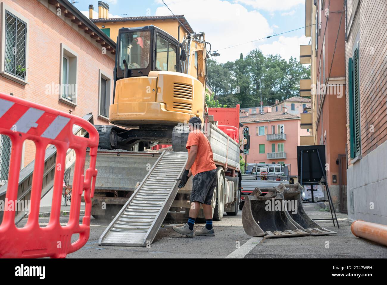 Zone de construction avec les opérateurs déployant la barrière, la pelle et le terrain de travail Banque D'Images