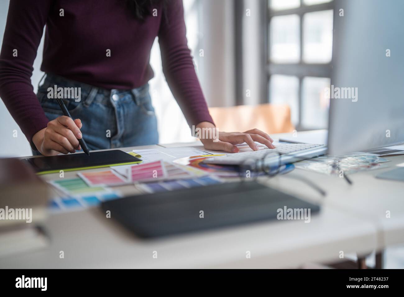 Graphiste femmes freelance écrivant sur tablette numérique à penser des idées créatives pour la marque de logo tout en tapant sur l'ordinateur et en travaillant sur graphi Banque D'Images