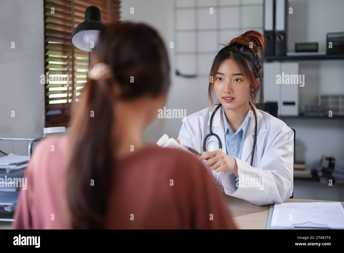 Femmes psychologue asiatique montrant la bouteille de pilules pour expliquer la médecine et la prescription au patient féminin tout en donnant des conseils pour expliquer à propos de moi Banque D'Images