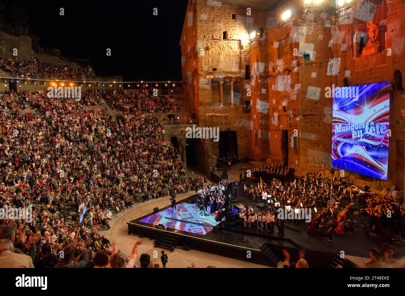 Public et interprètes lors d'un concert gratuit à l'occasion de la Fête nationale de la musique dans l'amphithéâtre romain d'Orange, Vaucluse, France. Banque D'Images