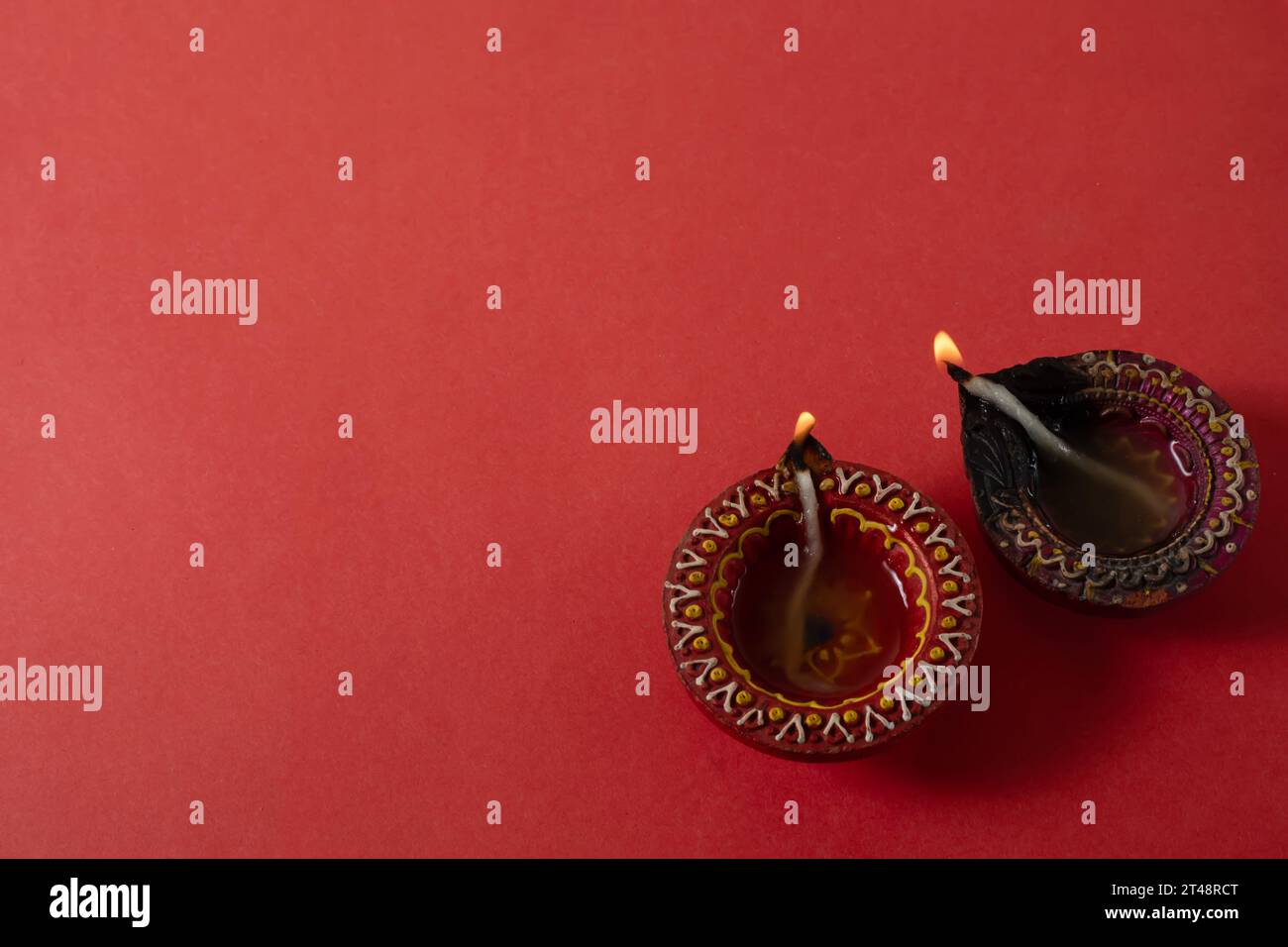 Joyeux Diwali et Kartika Deepam Festival Salutations - lampe colorée de diya d'argile sur fond rouge Banque D'Images