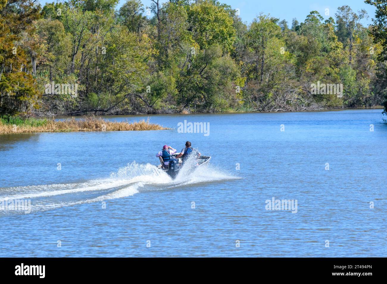 LAKE FAUSSE POINTE STATE PARK, LA, USA - 25 OCTOBRE 2023 : vue arrière d'un homme et d'une femme dans un bateau à moteur dans la voie navigable du bassin de la rivière Atchafalaya Banque D'Images