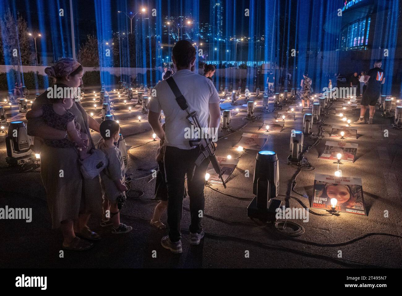 Jérusalem, Israël. 29 octobre 2023. Une famille israélienne religieuse regarde les affiches de quelques-uns des 229 Israéliens retenus en otage par le Hamas dans la bande de Gaza lors d’une veillée nocturne tenue devant un stade sportif au sud de Jérusalem le 29 octobre 2023. La veillée a des portraits de tous les otages disposés sur une terrasse et sera illuminée chaque nuit jusqu'à ce que les otages pris le 7 octobre 2023 lors de l'attaque terroriste du Hamas soient libérés. Photo de Jim Hollander/UPI crédit : UPI/Alamy Live News Banque D'Images Jérusalem, Israël. 29 octobre 2023. Une famille israélienne religieuse regarde les affiches de quelques-uns des 229 Israéliens retenus en otage par le Hamas dans la bande de Gaza lors d’une veillée nocturne tenue devant un stade sportif au sud de Jérusalem le 29 octobre 2023. La veillée a des portraits de tous les otages disposés sur une terrasse et sera illuminée chaque nuit jusqu'à ce que les otages pris le 7 octobre 2023 lors de l'attaque terroriste du Hamas soient libérés. Photo de Jim Hollander/UPI crédit : UPI/Alamy Live News Banque D'Images
