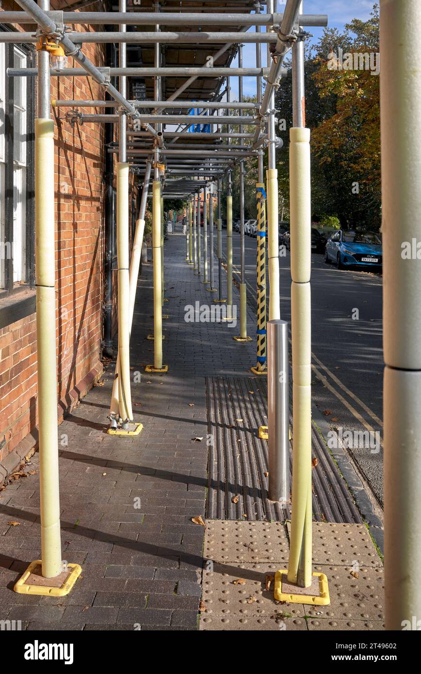 Échafaudage protégé par des tubes de mousse sur une promenade de trottoir pour la sécurité des piétons. Angleterre, Royaume-Uni Banque D'Images