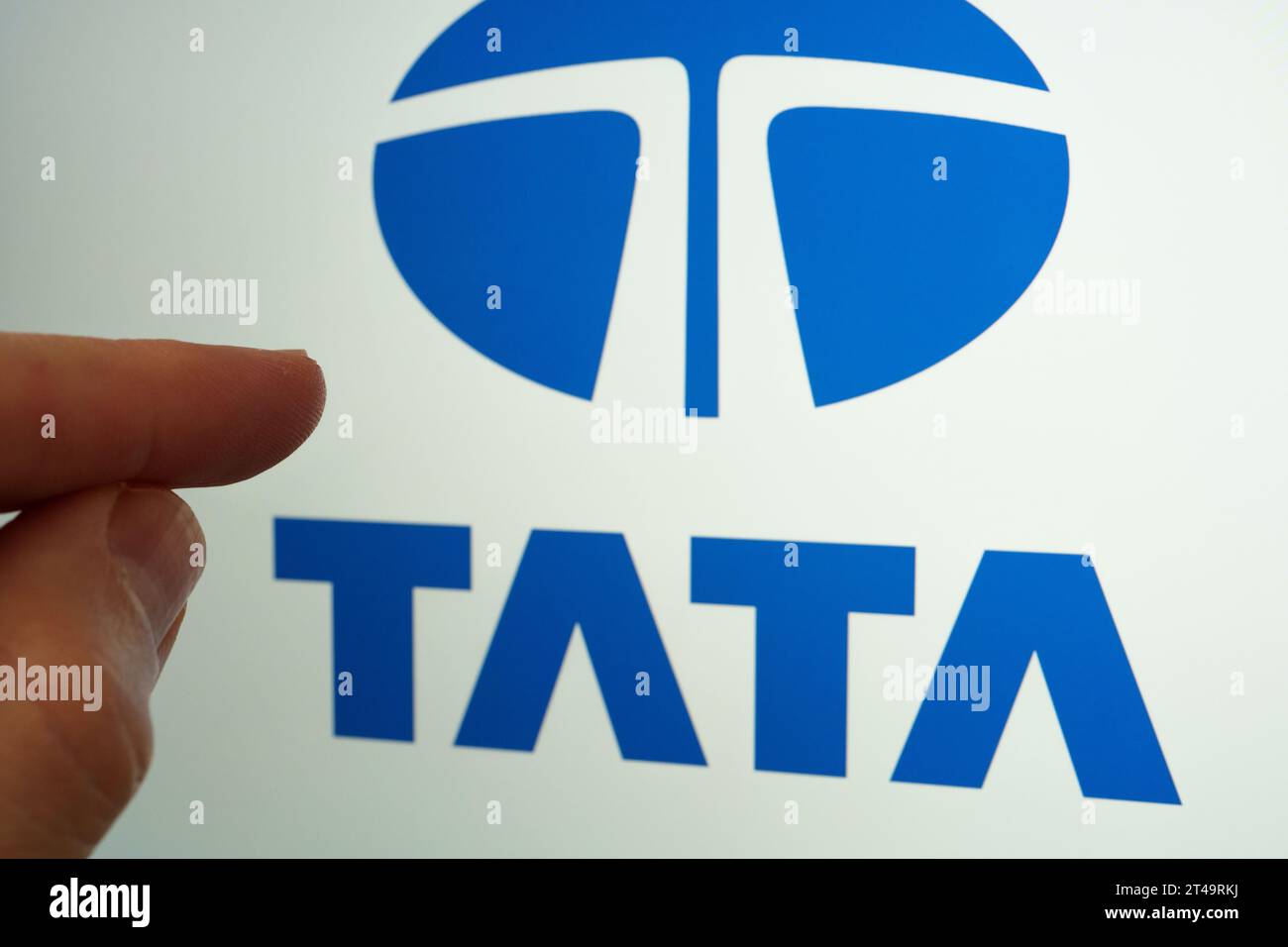 Logo du groupe Tata visible sur l'écran et le doigt le touchant. Concept. Stafford, Royaume-Uni, 29 octobre 2023 Banque D'Images