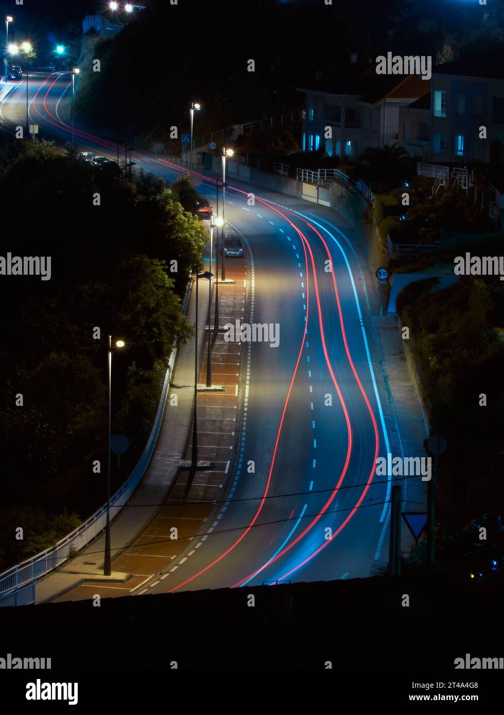 Une scène nocturne fascinante comme les lumières de voiture créent des stries lumineuses sur une route éclairée Banque D'Images