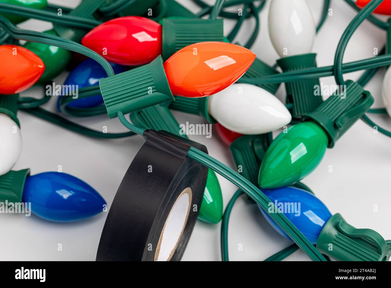 Réparation des fils sur les guirlandes de Noël avec du ruban isolant. Concept de réparation d'éclairage de vacances, de sécurité et de décoration. Banque D'Images