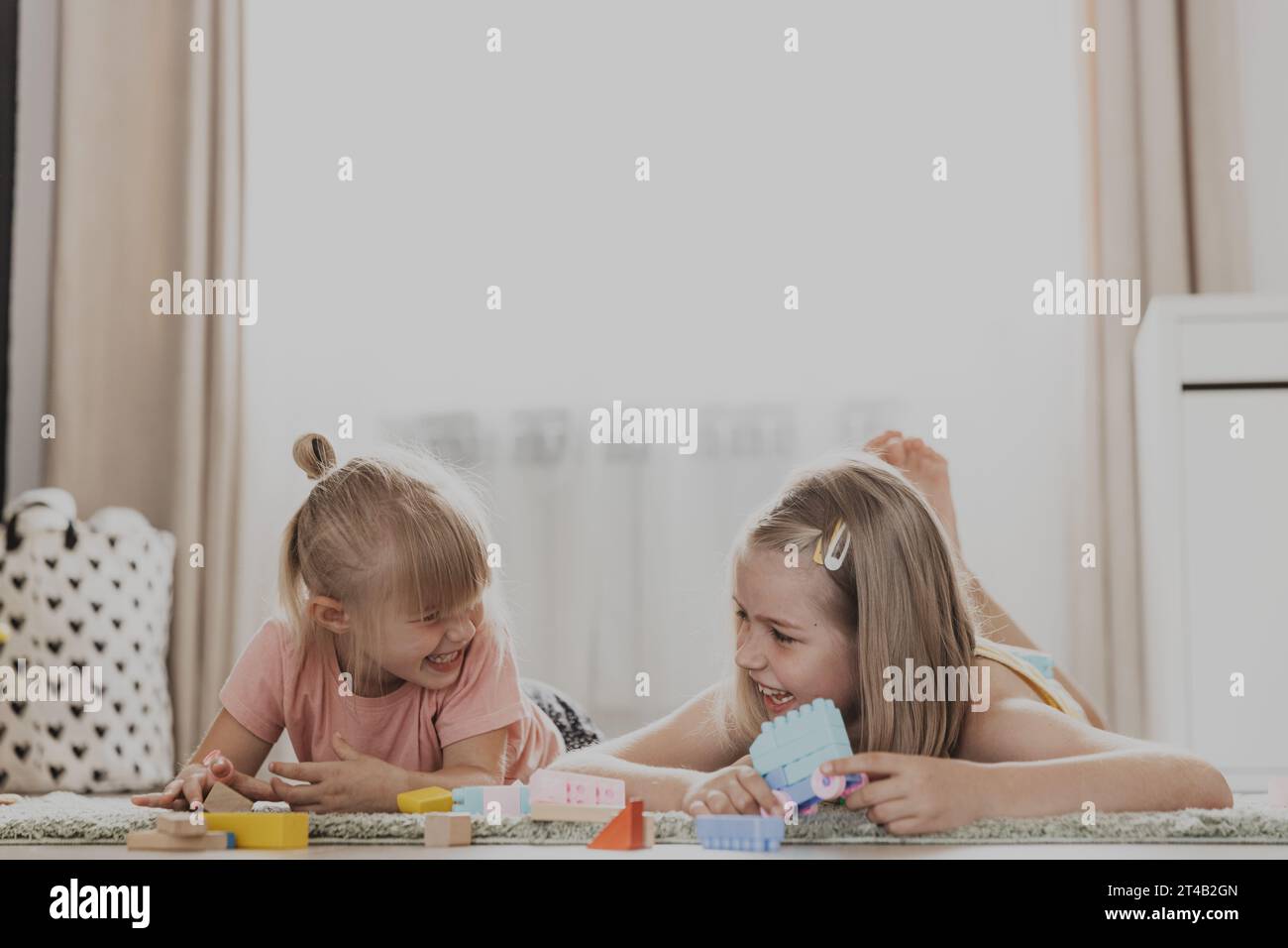 Enfants jouant avec des jouets colorés. Enfants couchés sur la moquette à la chambre à coucher ou à la maternelle. Développement de la motricité fine, imagination, concept de pensée logique. Jeux écologiques éducatifs Banque D'Images