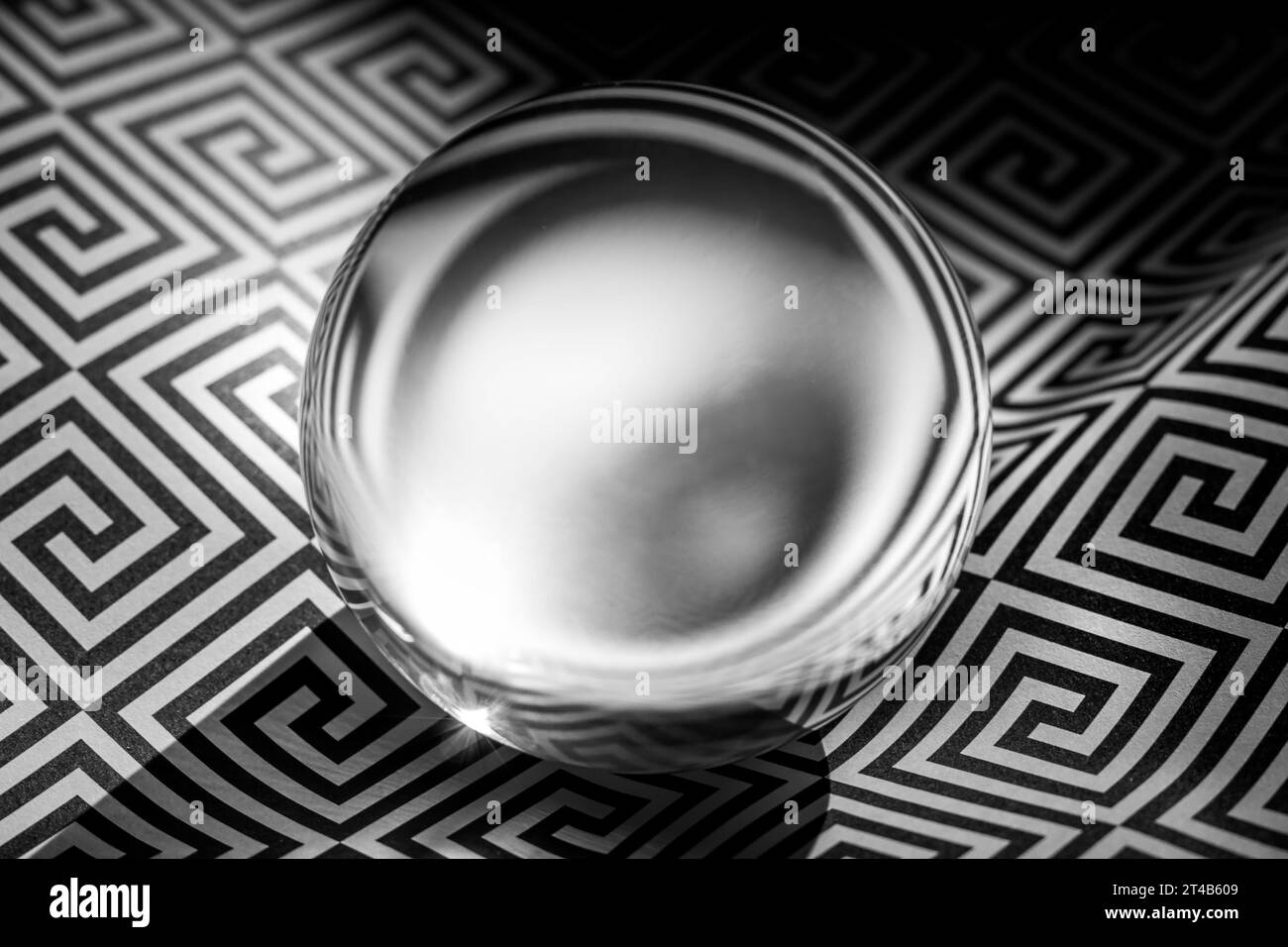 Sphère de verre sur un motif géométrique noir et blanc, espace de copie Banque D'Images