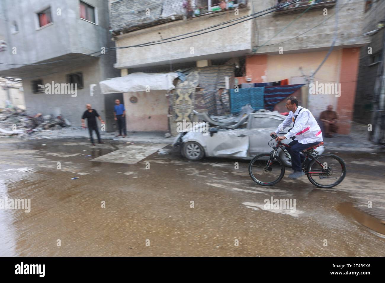 Le Dr Hassan Zein Al-DIN fait du vélo à l'intérieur d'une école des Nations Unies pour soigner les personnes déplacées par la guerre dans le camp d'Al-Bureij, dans le centre de la bande de Gaza. Palestinien Dr Hassan Zein al-DIN, 54 ans, spécialiste de la médecine générale et des maladies chroniques. Il a été déplacé de la ville de Gaza vers la région de Bureij en raison de la guerre. Il se déplace à vélo entre les centres d’accueil pour soigner les déplacés et assurer le suivi de leurs cas au quotidien. Il se rend dans la ville de Gaza pour suivre les cas d’un certain nombre de patients dans les centres d’hébergement laissés par l’administration de l’UNRWA. À cause de l'ISR Banque D'Images