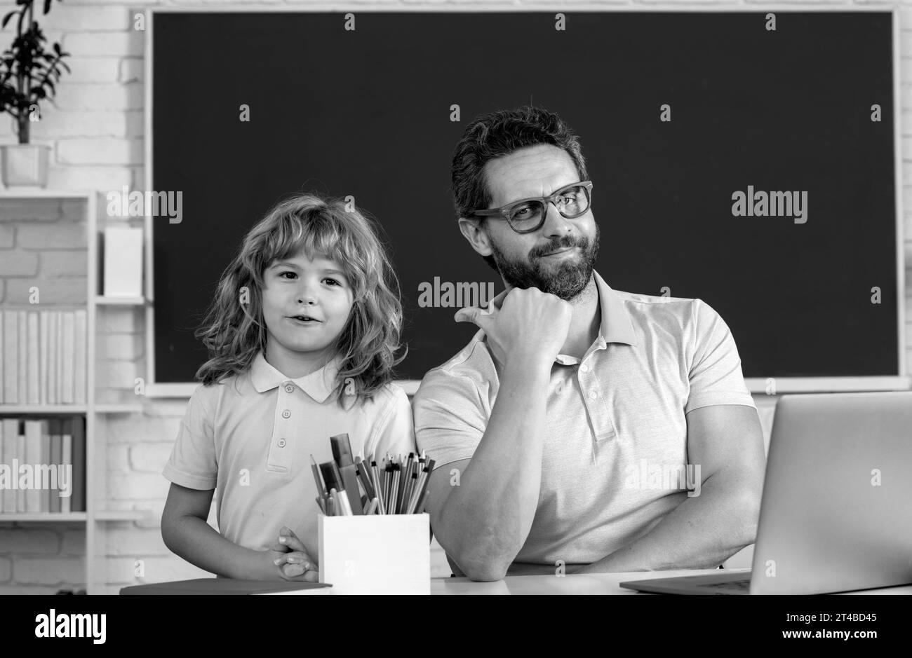 Professeur de père aidant un garçon de fils dans les cours d'école. Éducation et connaissances. Banque D'Images