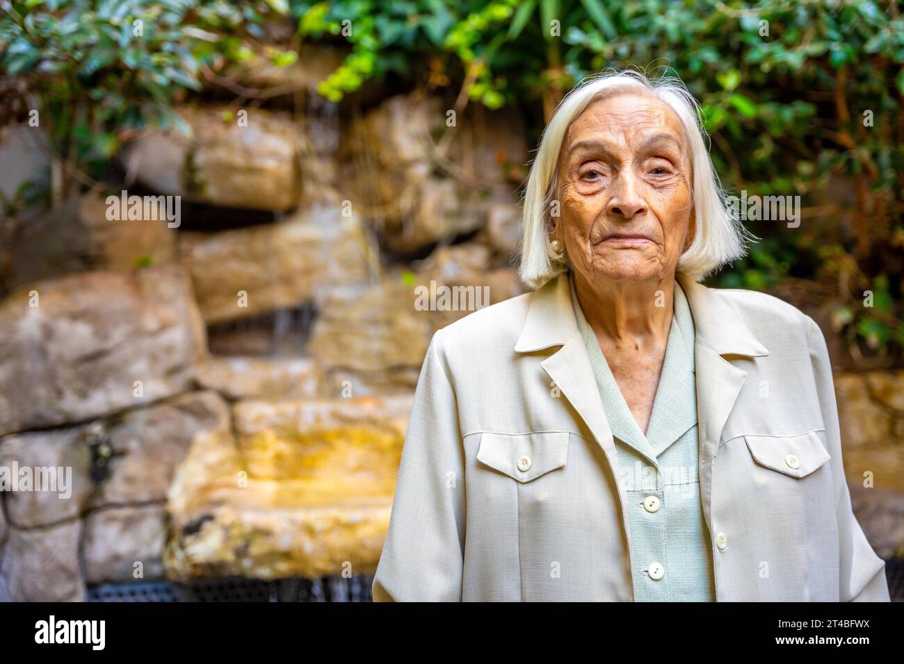 Portrait d'une femme aînée dans le jardin d'une maison de retraite Banque D'Images