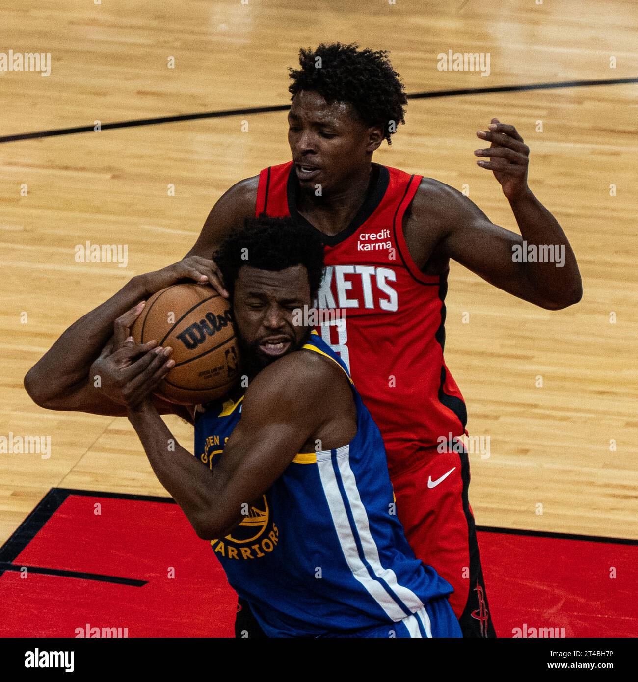 Huston, États-Unis. 29 octobre 2023. Andrew Wiggins (en bas) des Golden State Warriors et Jae'Sean Tate des Houston Rockets s'affrontent lors du match de saison régulière de la NBA 2023-2024 entre Houston Rockets et Golden State Warriors à Houston, Texas, États-Unis, le 29 octobre 2023. Crédit : Chen Chen/Xinhua/Alamy Live News Banque D'Images