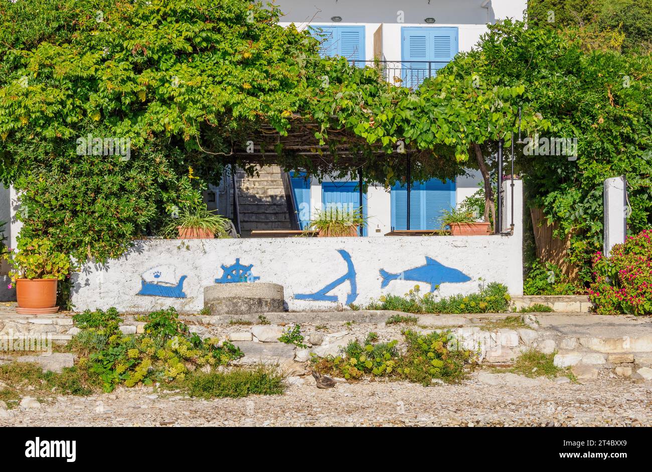 Maison sur la plage avec des fresques nautiques sur son mur sur la côte nord des îles Ioniennes de Corfou Grèce Banque D'Images